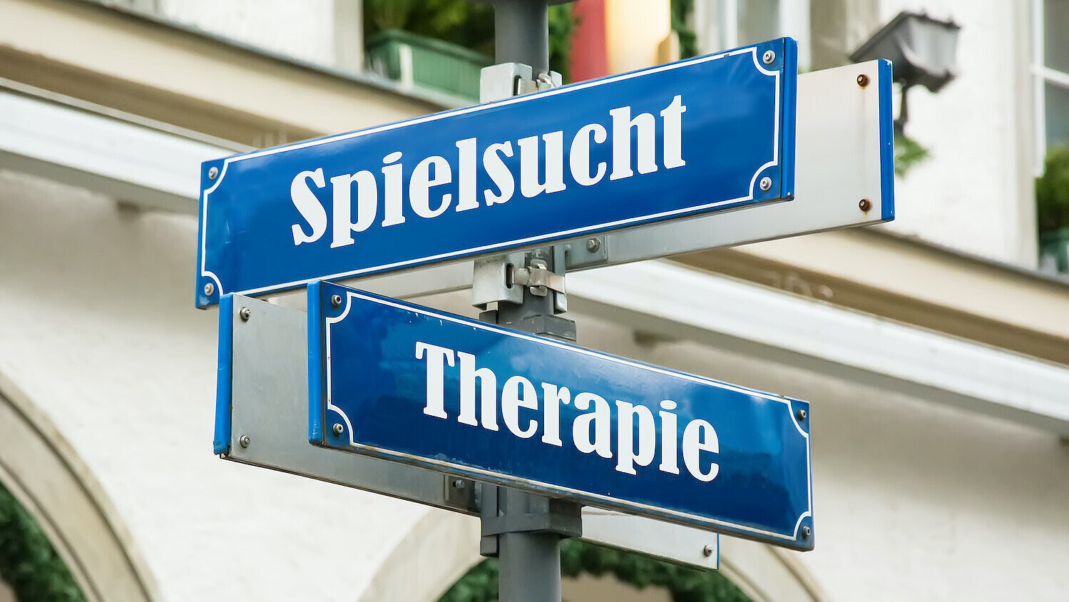 Blaue Straßenschilder mit den Bezeichnungen "Spielsucht" und "Therapie"