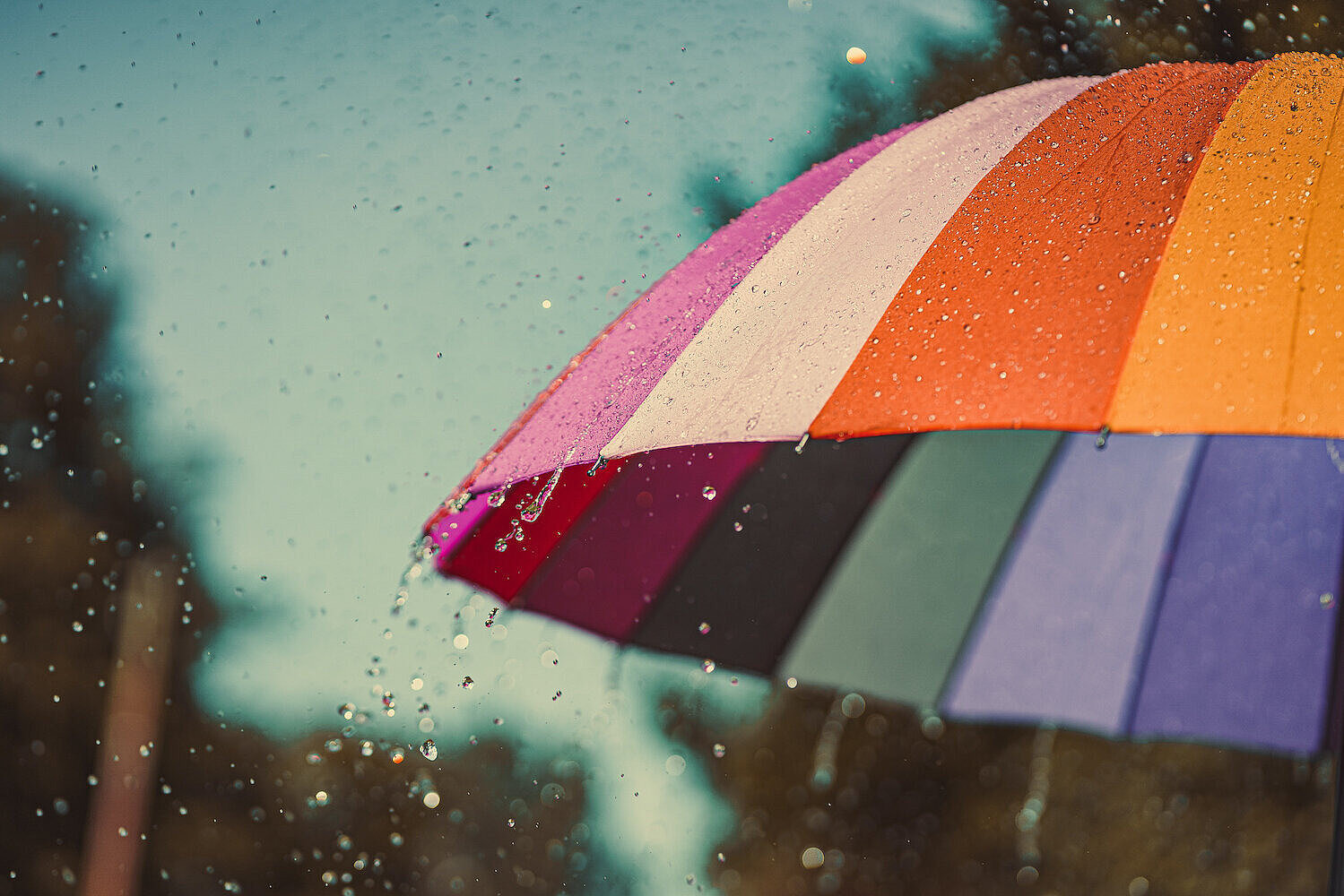 Bunter Regenbogen-Regenschirm bei Regenwetter