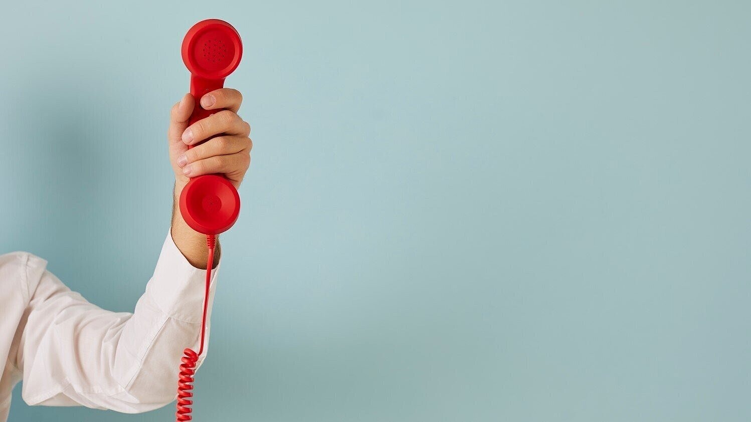 Person hält roten Hörer in der Hand als Beispielbild für eine Telefonberatung
